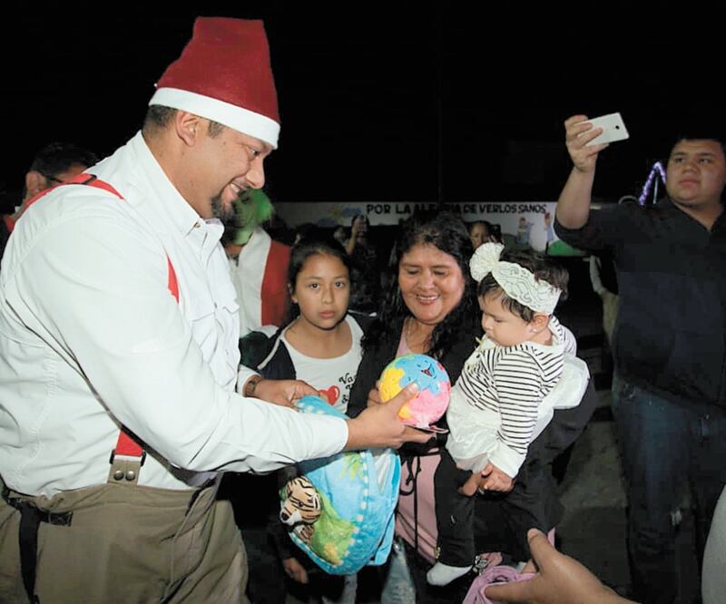 Los bomberos cambiaron sus uniformes habituales por un atuendo navideño para repartir juguetes a los niños. ESPECIAL