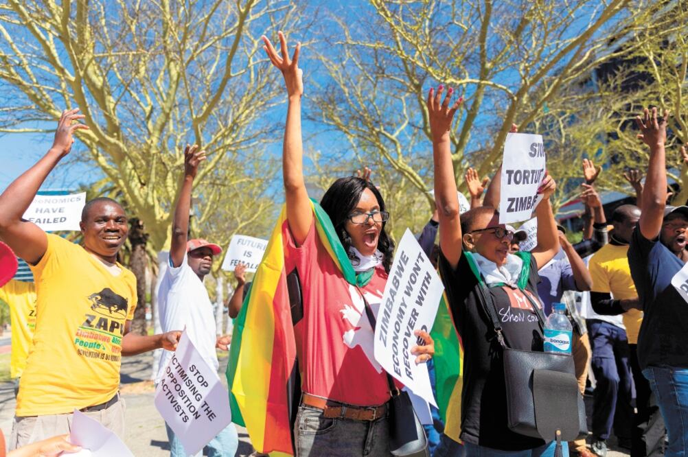 Ciudadanos de Zimbabue celebraron en Sudáfrica la muerte del expresidente Robert Mugabe. Foto/NIC BOTHMA. EFE