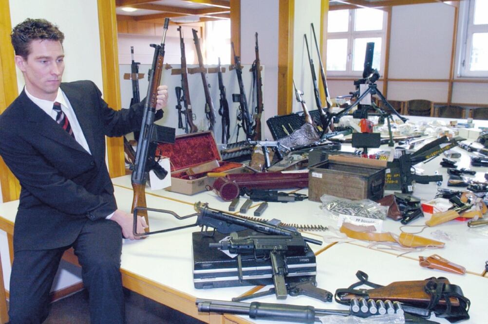 Golpe. Un detective muestra las armas confiscadas a una organización dedicada al tráfico, en Dusseldorf, Alemania. 