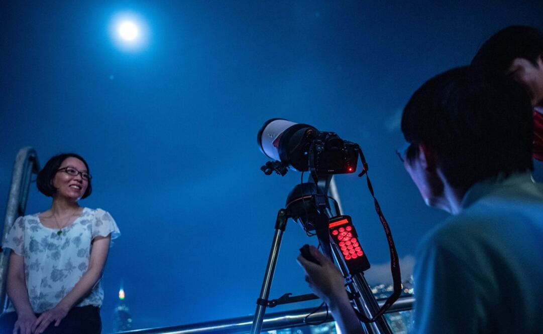 La gente toma fotografías antes del eclipse de Luna en Hong Kong. Foto: AFP