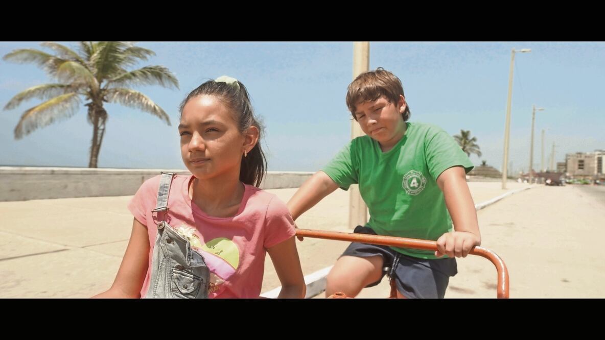 Un niño (Hugo Benítez) que trabaja repartiendo garrafones se cruza con una pequeña (Marsell Moreno), quien le propone vivir una aventura. Foto: José Eduardo Castilla