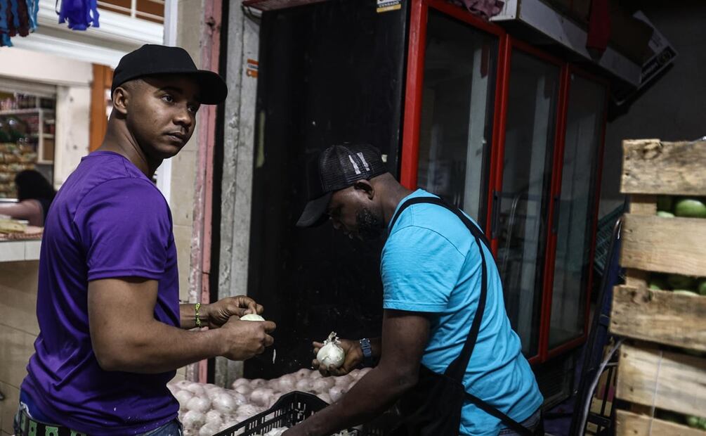 Dairon, de Cuba, y Francis,de República Dominicana, son dos migrantes que trabajan en el Mercado Nezahualcoyotl. Foto: Gabriel Pano El Universal