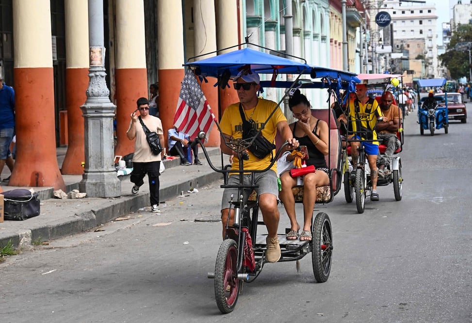 Un triciclo decorado con la bandera de Estados Unidos circula por una calle de La Habana. Foto: AFP