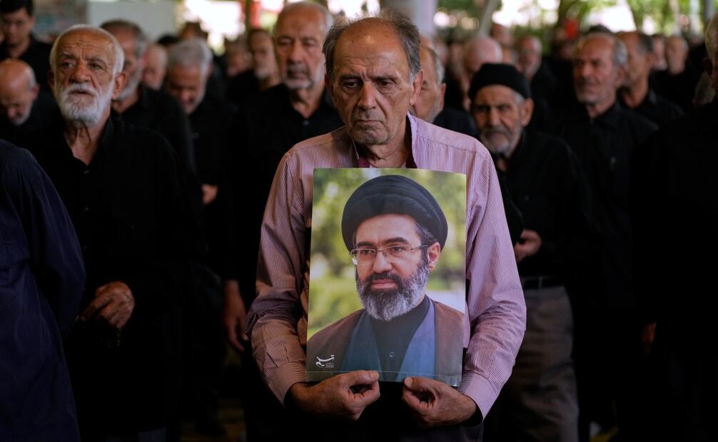 Fieles iraníes escuchan un sermón en la oración del viernes mientras uno de ellos sostiene un cartel con la imagen del líder supremo del país, el ayatolá Mojtba Jamenei. Foto: AP