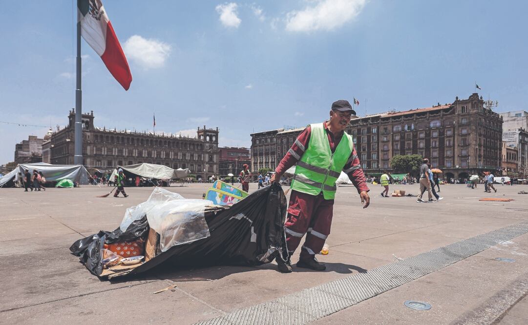 Trabajadores de limpieza arrastran parte de los desechos que dejaron los maestros, luego de levantar el plantón del Zócalo.  Foto: Gabriel Pano/ EL UNIVERSAL