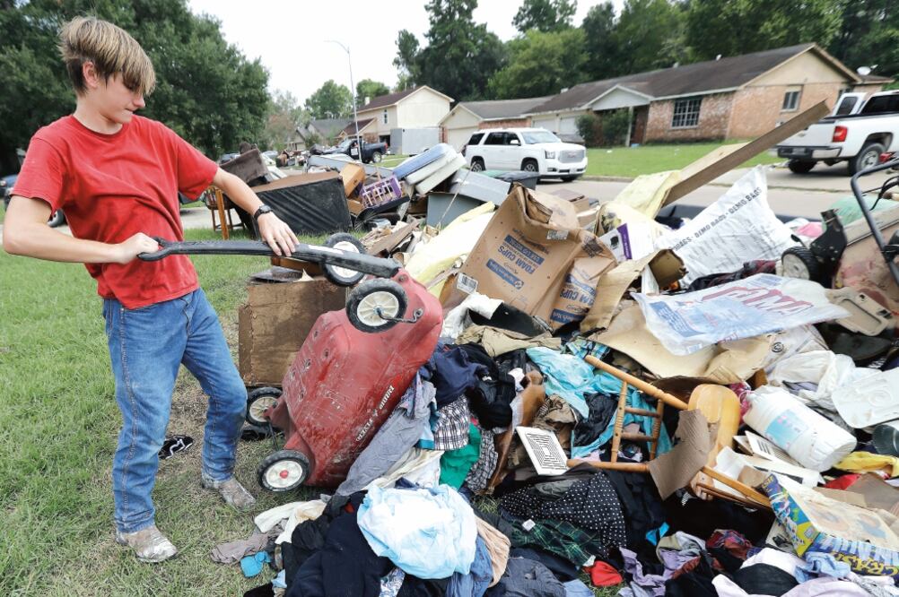 Alex Brewer, un voluntario, ayuda a remover ropa dañada por la inundación de una casa en Houston. Expertos han alertado a la población sobre los riesgos que representan las aguas estancadas en las casas, ya que se mezclaron con drenajes (DAVID J. PHILLIP)