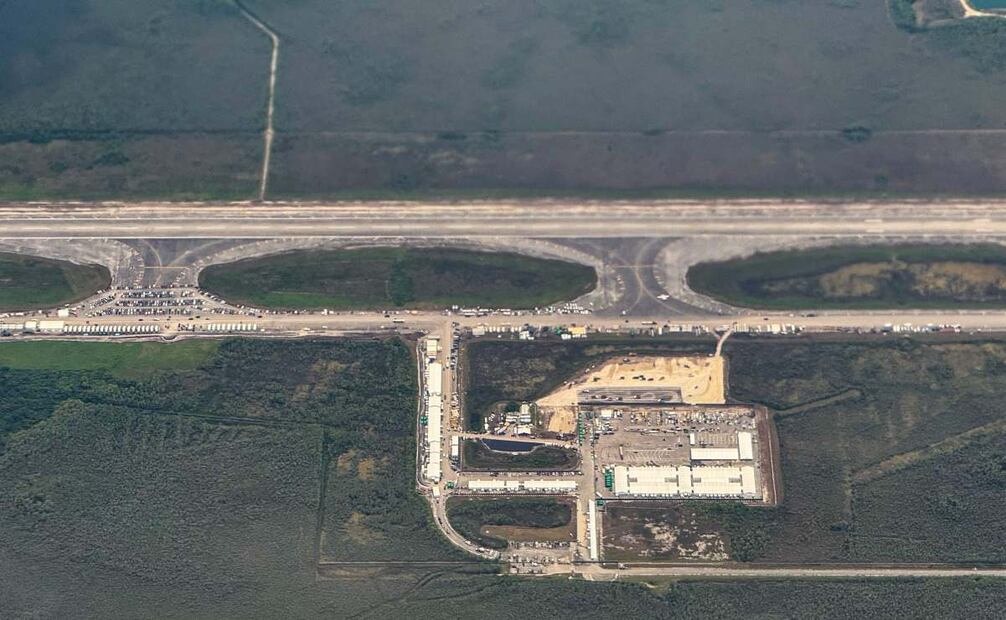 Vista aérea de un centro de detención de migrantes, conocido como "Alcatraz Caimán", ubicado en el antiguo Aeropuerto de Entrenamiento y Transición Dade-Collier en Ochopee, Florida, el 7 de julio de 2025. El campamento, con un costo de 450 millones de dólares, se construyó en un aeródromo en desuso en lo profundo de los Everglades de Florida y está rodeado de pantanos que albergan criaturas como caimanes y serpientes venenosas. El sitio, sofocante e infestado de mosquitos, simboliza la determinación del gobierno republicano de mostrarse firme en su política de deportaciones masivas de migrantes indocumentados. Foto: AFP