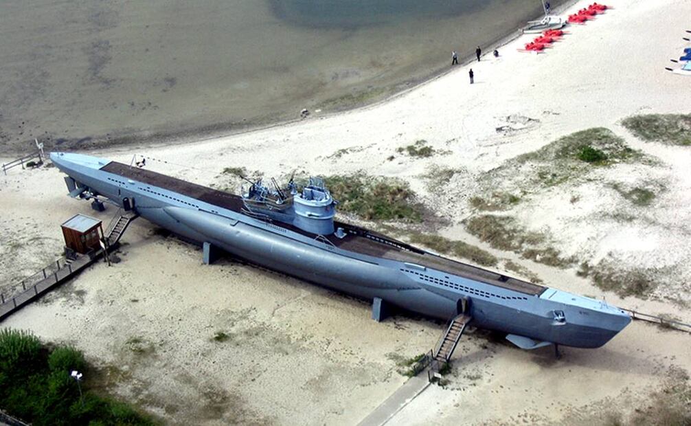 Esta imagen aérea de un submarino tipo VIIC ayuda a darse una idea de su tamaño, gracias a las personas de pie sobre la costa (arriba). Wikimedia Commons.