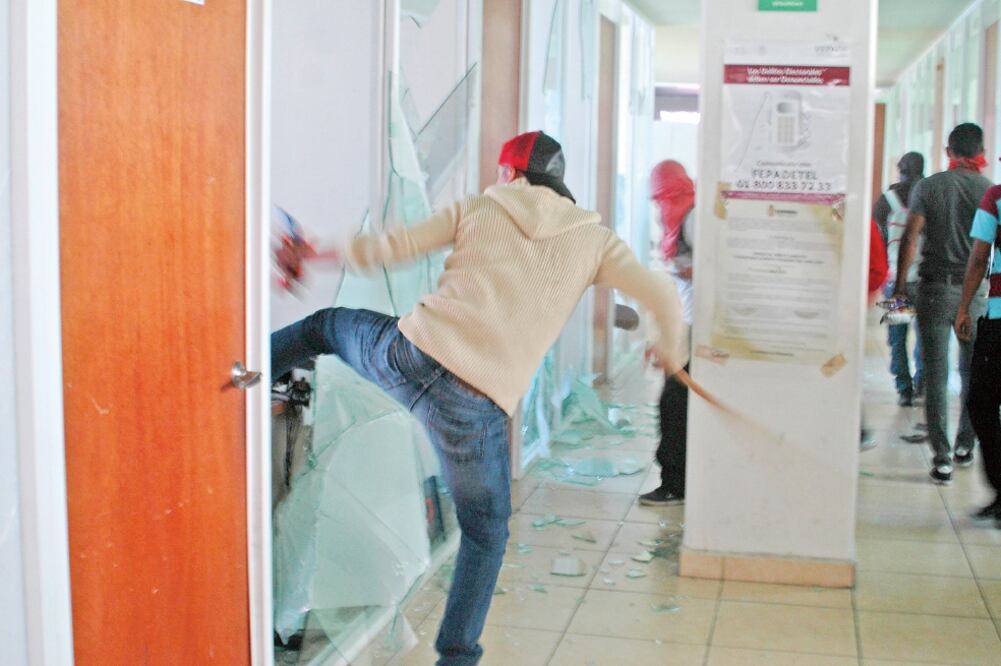 Cubiertos del rostro, los jóvenes se introdujeron a las instalaciones alrededor de las 10:50 de la mañana (DASSAEV TÉLLEZ. EL UNIVERSAL)