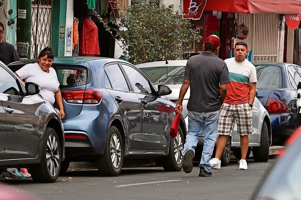 En la cuidad es bastante común encontrarse con grupos de franeleros que trabajan todos los días apartando lugares y cobrando a los automovilistas. Foto: Berenice Fregoso