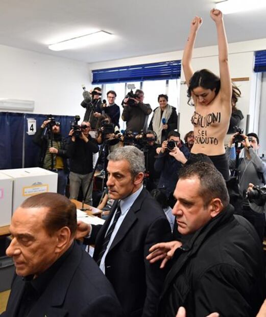 ​Activista sin camiseta intercepta a Berlusconi durante votación