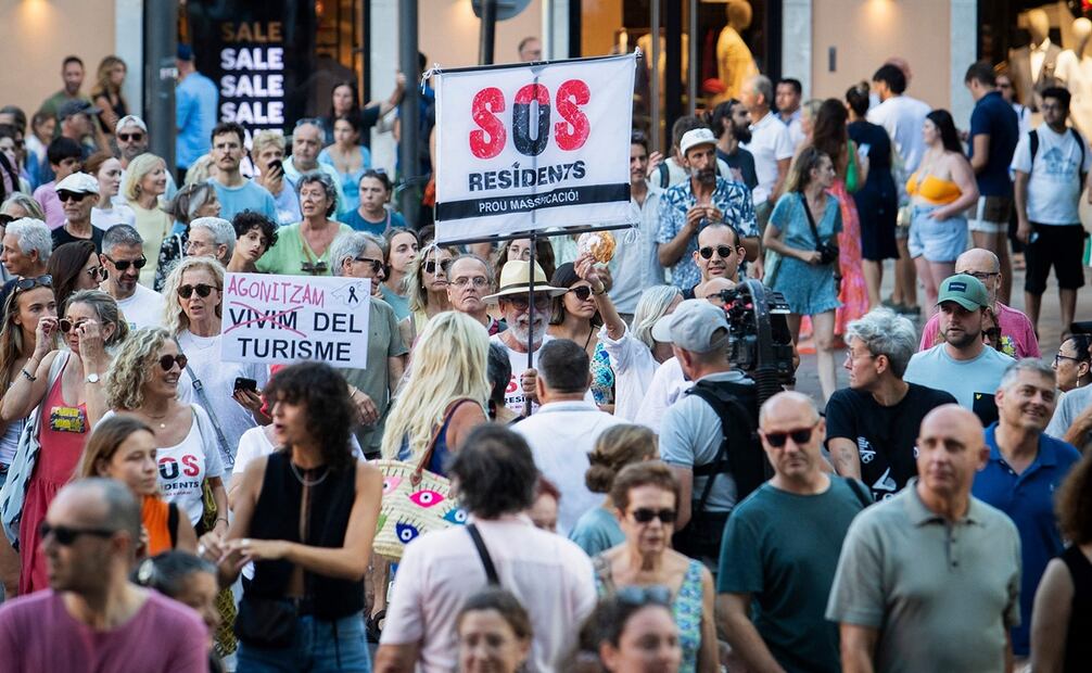 "SOS Residentes", se lee en una pancarta de manifestantes que protestan contra el sobreturismo y los precios de la vivienda en Mallorca. Foto: JAIME REINA / AFP)