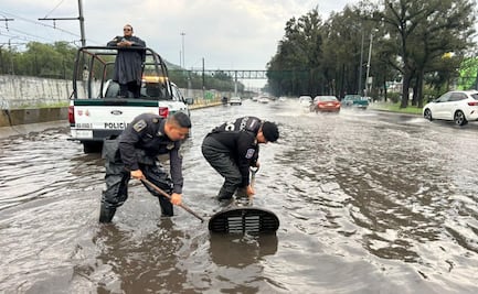 FOTOS. Elementos de la policía ribereña de la SSC destapan coladeras en Calzada Ignacio Zaragoza para evitar vehículos varados en los encharcamientos