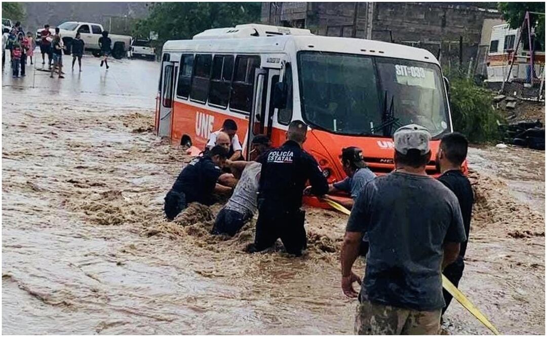 La unidad de transporte urbano quedó varada en una fuerte corriente de agua en la colonia Laura Alicia Frias, al norte de Sonora. Foto: Especial
