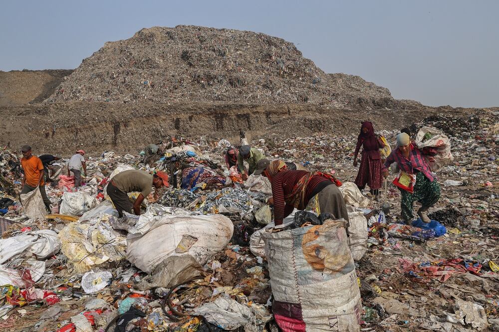 Recolectores de residuos buscan artículos reutilizables entre los residuos vertidos en un vertedero en Nueva Delhi, India. Foto: EFE