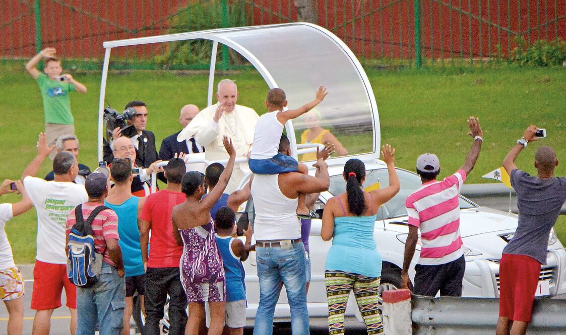 El Papa saluda a los cubanos que se congregaron ayer en las calles de La Habana para verlo pasar, en su camino del aeropuerto a la Nunciatura (ADALBERTO ROQUE. AP)
