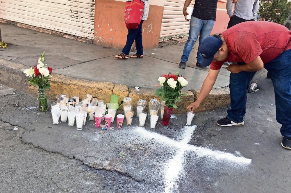 Ofrenda. Habitantes colocaron velas y flores en el lugar donde quedaron tendidos los cuerpos de los policías. (Archivo. EL UNIVERSAL)