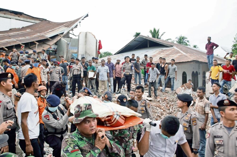 El equipo de Búsqueda y Rescate (SAR, por sus siglas en inglés) se lleva los cuerpos de las víctimas del terremoto en el distrito Pidie Jaya, en la provincia de Aceh. Miles de personas participan en la localización de sobrevivientes. (XINHUA)