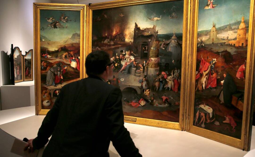 Un hombre observa el "Tríptico de las Tentaciones de San Antonio" previo a la apertura al público de la muestra en el Museo del Prado. (FOTO: EFE)