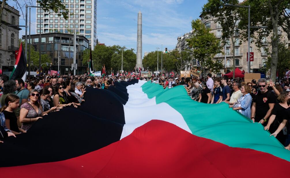 Participantes despliegan una bandera palestina durante la manifestación convocada por más de 600 entidades y sindicatos en apoyo a Palestina y contra el "genocidio" de Israel, este sábado, en Barcelona. Foto: EFE
