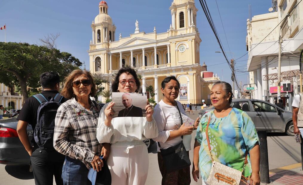 Una mujer muestra una foto donde aparece el papa León XIV frente a la iglesia Santa María Catedral, en Chiclayo, Perú. Los católicos de Perú celebraron este jueves como "una bendición" para su país y "una alegría que no se puede describir" que se haya elegido al estadounidense-peruano Robert Prevost como el nuevo Papa. Foto: EFE