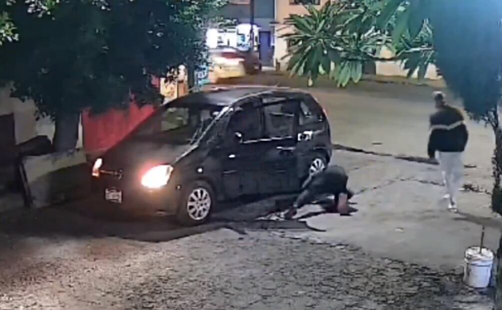 El conductor, baja de su vehículo y ve a la mujer debajo de su auto. Inmediatamente después vuelve a subir a su auto y huye. Foto: Especial