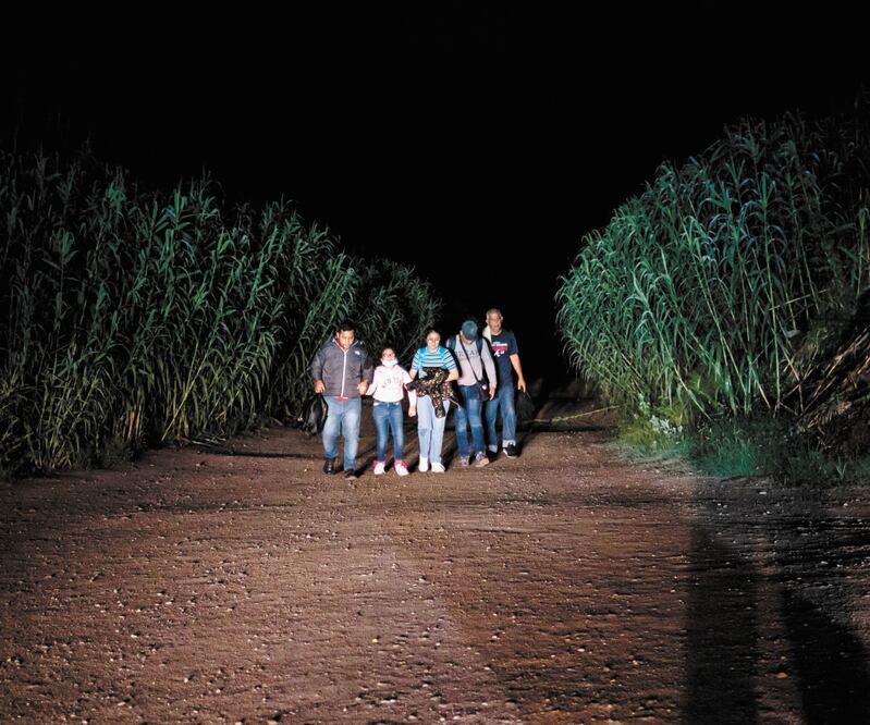 Una familia camina hacia la policía estatal de Texas después de cruzar el río Bravo. Foto: SERGIO FLORES. AFP