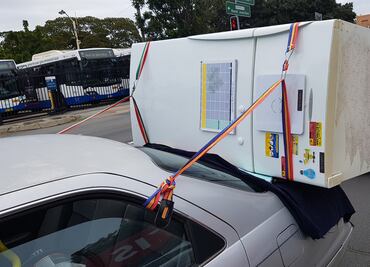 Conductor intenta llevar refrigerador sobre la cajuela de un auto, la policía lo detiene