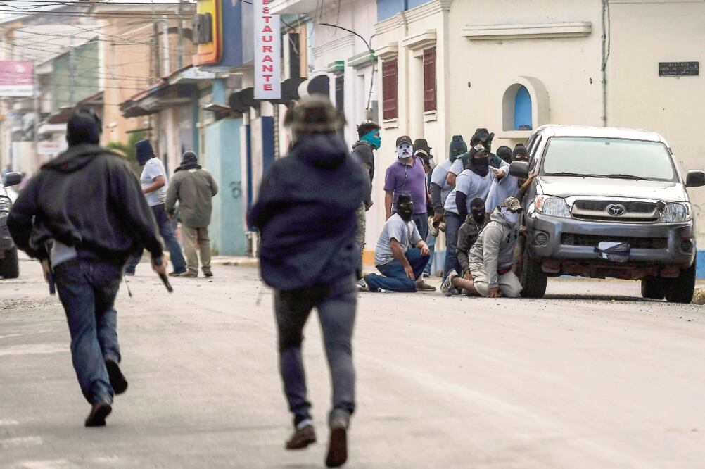 Paramilitares previo a la irrupción, el lunes, en la basílica de San Sebastián, donde agredieron a obispos y periodistas, en Diriamba, Nicaragua. (MARVIN RECINOS. AFP)