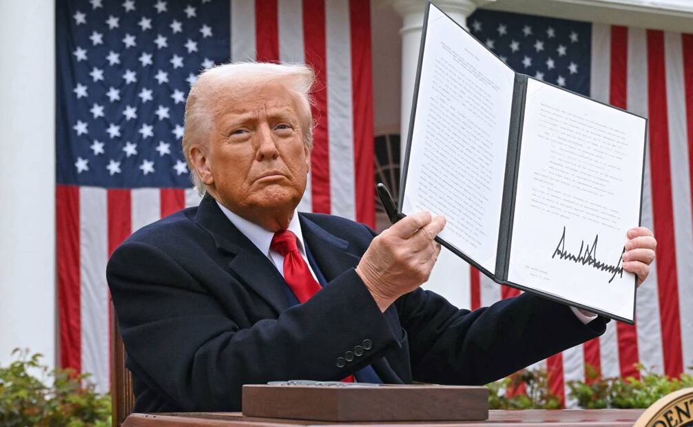 El presidente Donald Trump sostiene una orden ejecutiva firmada tras pronunciar un discurso sobre aranceles recíprocos durante un evento en el Jardín de las Rosas titulado "Hagamos que Estados Unidos vuelva a ser rico" en la Casa Blanca en Washington, D.C., el 2 de abril de 2025. Trump se preparaba para revelar los nuevos y radicales aranceles del "Día de la Liberación", una medida que amenaza con desencadenar una devastadora guerra comercial global. Socios comerciales clave de EU, como la Unión Europea y el Reino Unido, afirmaron estar preparando sus respuestas a la escalada de Trump, ante la inestabilidad de los mercados en Europa y Estados Unidos. Foto: AFP