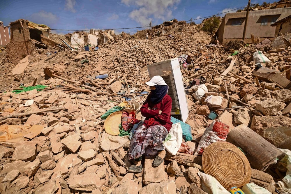 Una mujer, junto a un refrigerador y otros artículos, en medio de los escombros en la aldea de Douzrou, afectada por el terremoto en las
montañas del Alto Atlas en Marruecos. Foto: Fadel Senna | AFP