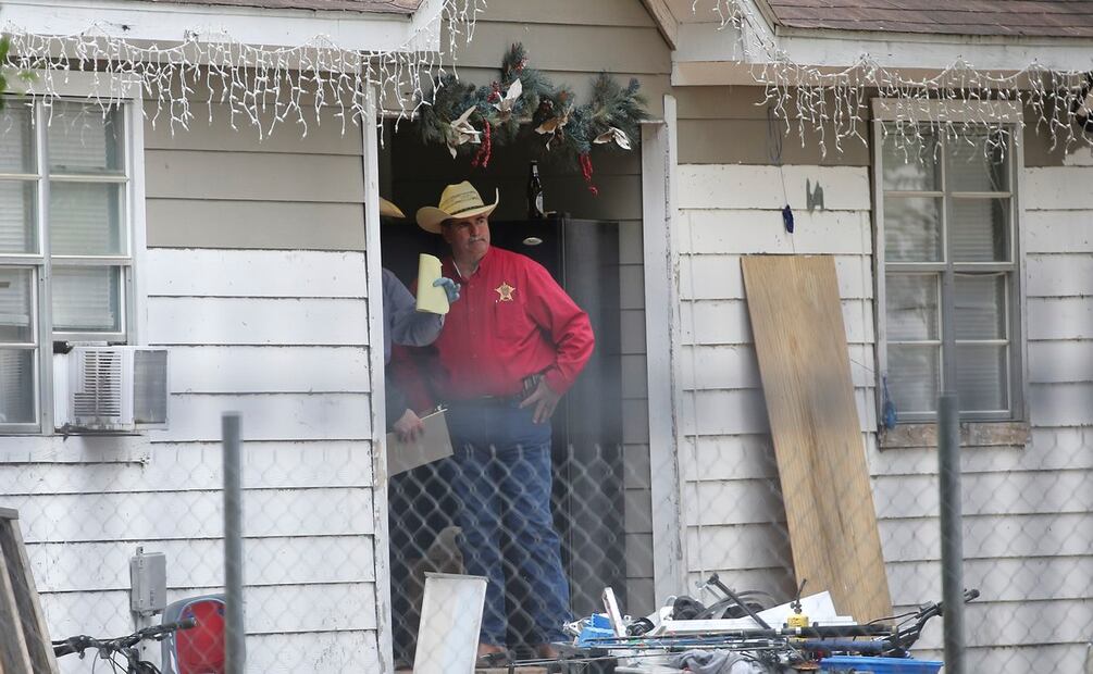 El alguacil del condado de San Jacinto, Greg Capers, habla con investigadores en la escena del crimen donde cinco personas fueron asesinadas. FOTO: AP