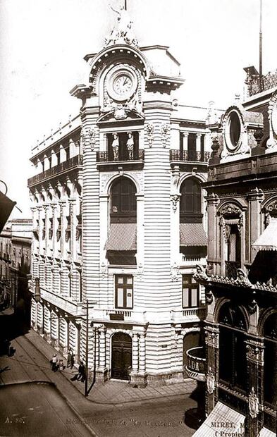 Del lado derecho de la imagen se observa la joyería La Esmeralda, al rededor de 1910. De frente, el edificio de la compañía de seguros La Mexicana, ubicado en la esquina de Plateros y San José el Real, hoy Madero e Isabel la Católica. Este inmueble fue planeado por Genaro Alcorta en 1906, ocupando el sitio donde antes había estado el café La Concordia; actualmente la planta baja es una tienda de ropa juvenil de marca conocida. Colección Villasana.