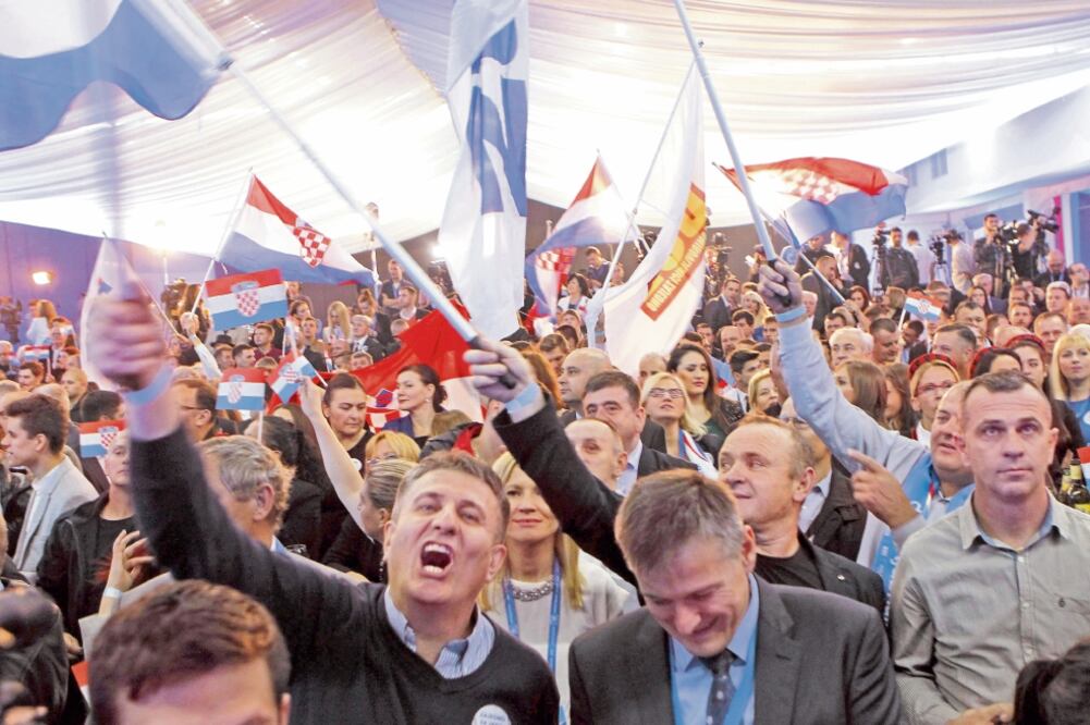 Seguidores de HDZ celebran la victoria, en Zagreb. La oposición conservadora ganó, pero tendrá que compartir el poder (ANTONIO BAT. EFE)