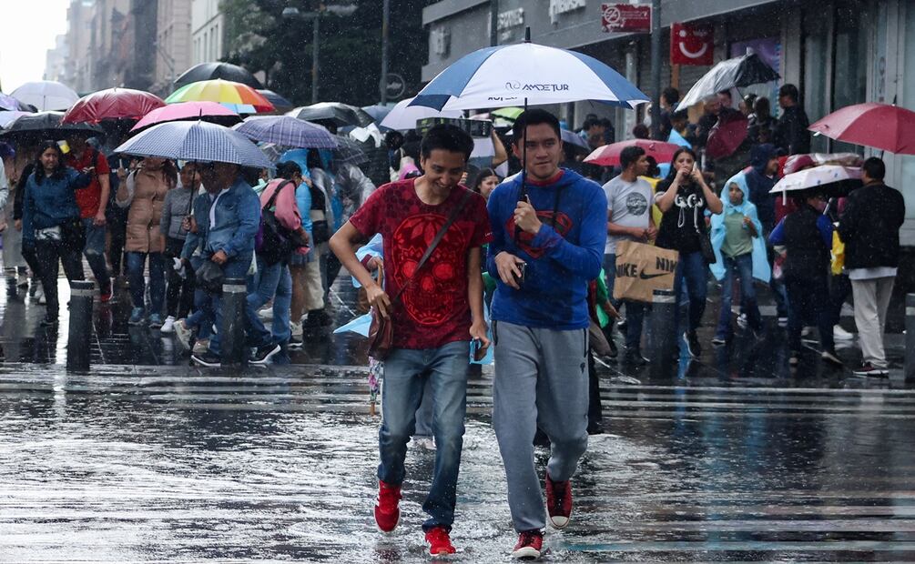 Capitalinos caminan bajo una fuerte lluvia en el Centro Histórico de la Ciudad de México. Foto Hugo Salvador El Universal