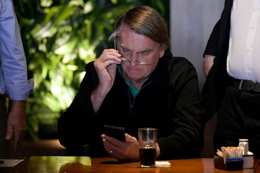 El expresidente brasileño Jair Bolsonaro revisa su teléfono antes de dirigirse a miembros de los medios de comunicación en Belo Horizonte, estado de Minas Gerais, Brasil, el 30 de junio de 2023. Foto: AFP