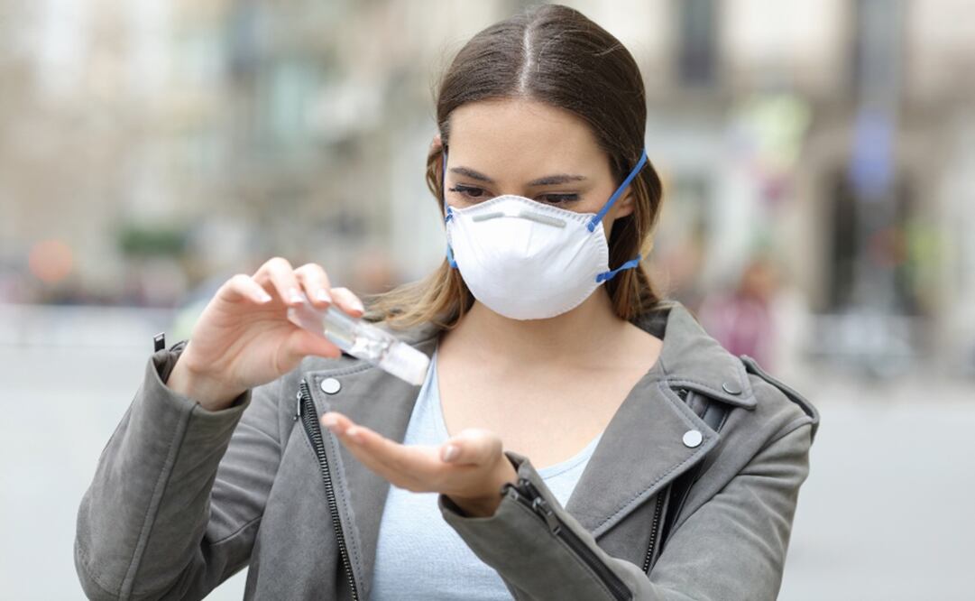 Portrait of a girl wearing protective mask applying sanitizer hand rub preventing contagion on city street – Photo: File photo/EL UNIVERSAL