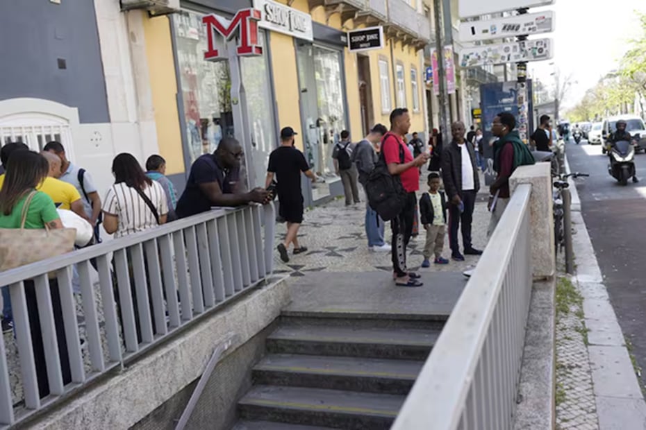 Las personas revisan sus teléfonos móviles mientras esperan fuera de una estación de metro cerrada tras un corte de energía en Lisboa, Portugal, el lunes 28 de abril de 2025. FOTO: ARMANDO FRANCA. AP