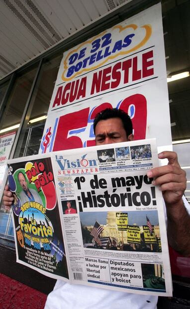 Fotografía del primero de mayo de 2006, en Georgia, Estados Unidos. Un migrante ilegal lee un periódico en español que avisa sobre el “histórico día” del boicot laboral y comercial. El hombre impide que alguien compre en una tienda de autoservicio estadounidense. Foto: Luis Cortés/EL UNIVERSAL.