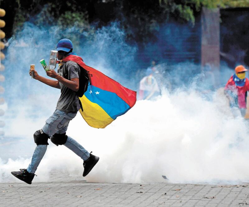Protesta. Un seguidor del líder opositor Juan Guaidó, ayer durante los enfrentamientos contra las fuerzas de seguridad, en Caracas. FEDERICO PARRA. AFP