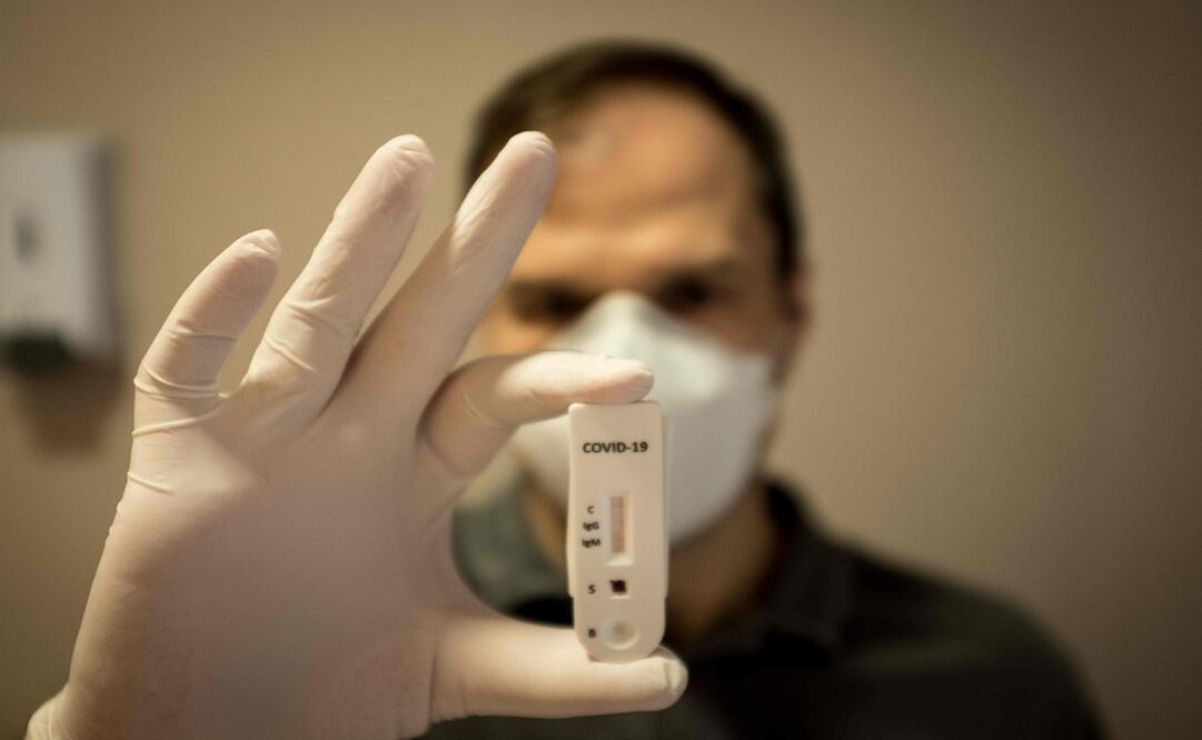 A doctor shows a rapid COVID-19 blood test - Photo: Florian Plaucheur/AFP