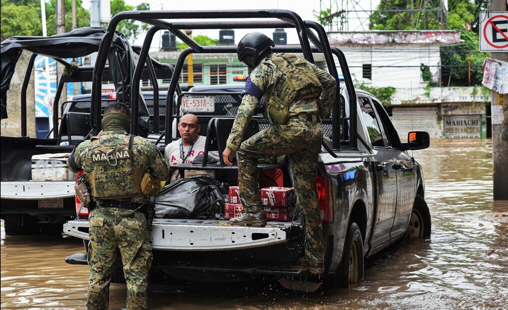 Militares custodian a un hombre en medio de las fuertes inundaciones registradas en la ciudad de Poza Rica, Veracruz, México, el viernes 10 de octubre de 2025. Foto: AFP