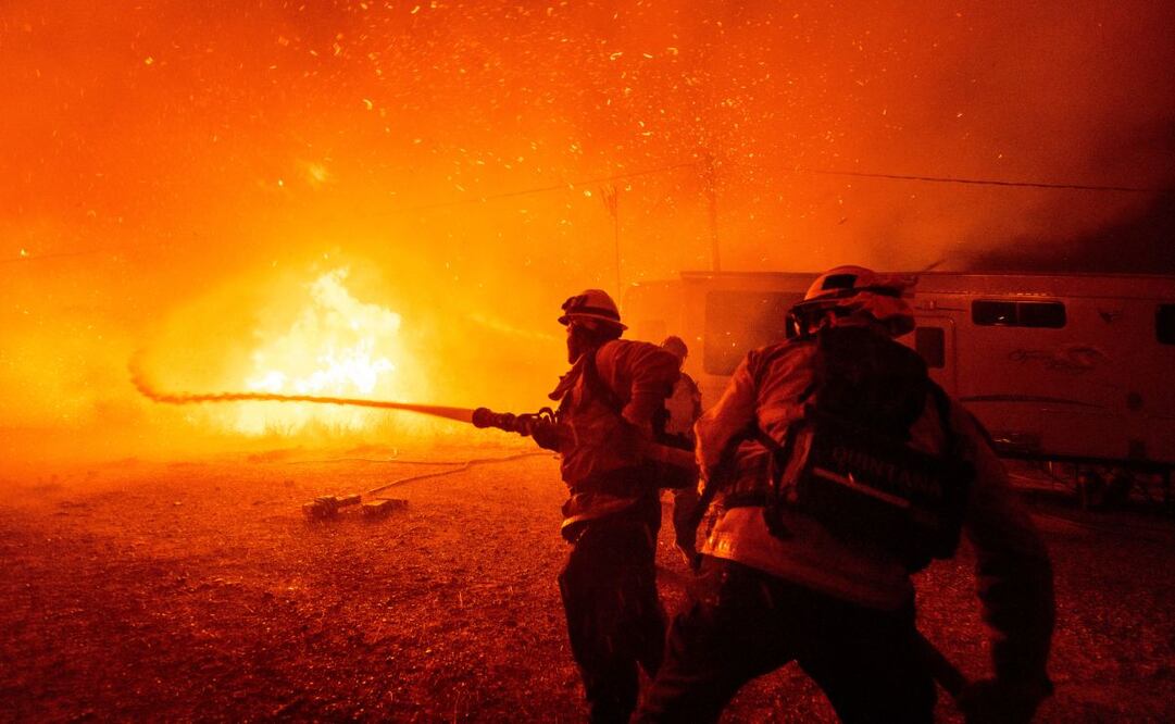 Bomberos rocían agua sobre el incendio Hughes en Castaic, Los Ángeles. Foto: AP