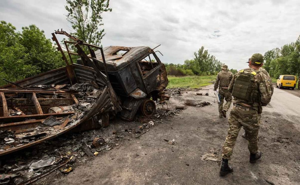 Soldados ucranianos patrullan en medio de vehículos destruidos durante una batalla en Ucrania. Foto: EFE