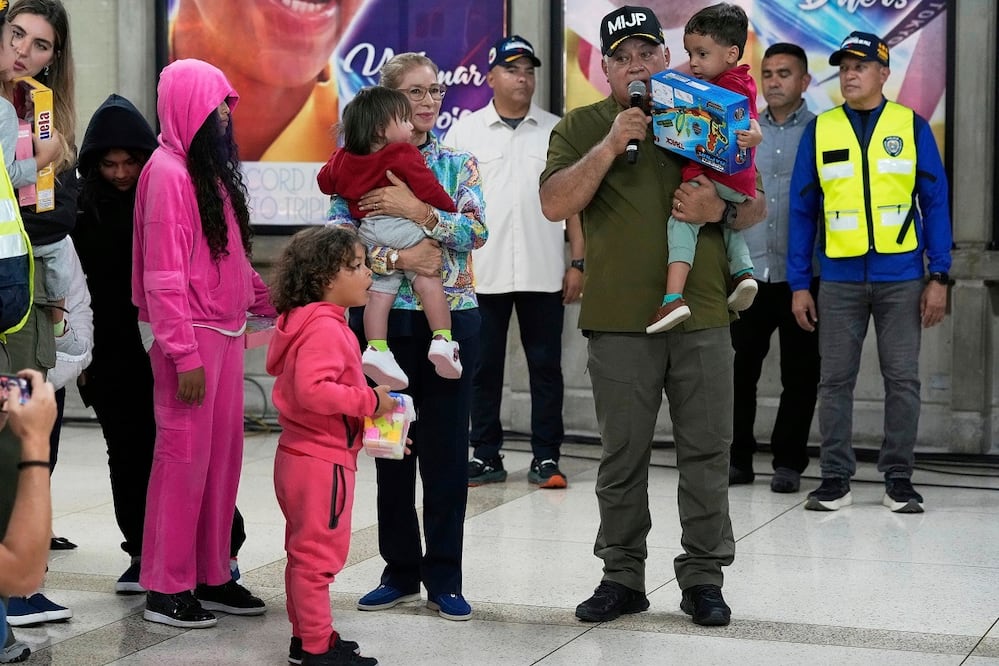 El ministro del Interior de Venezuela,  Diosdado Cabello, y la primera dama Cilia Flores, al recibir a niños venezolanos repatriados de Estados Unidos, en el Aeropuerto Internacional Maiquetia. FOTO: ARIANA CUBILLOS. AP