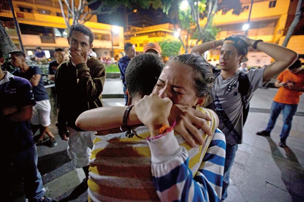 Partidarios de Leopoldo López lloran tras enterarse de la sentencia condenatoria que recibió anoche el líder opositor venezolano, en Caracas. La gente salió a las calles e hizo sonar cacerolas en señal de protesta (FERNANDO LLANO. AP)