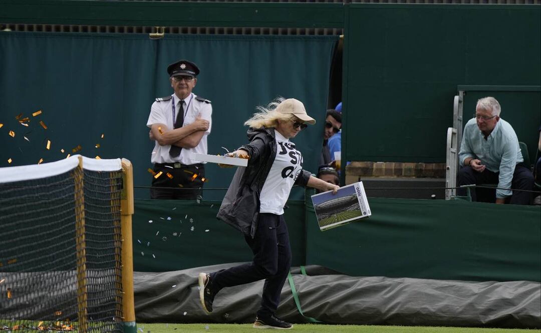 Una manifestante de Just Stop Oil corre hacia la Corte 18 y lanza confeti en el tercer día del campeonato de tenis de Wimbledon en Londres. Foto: AP