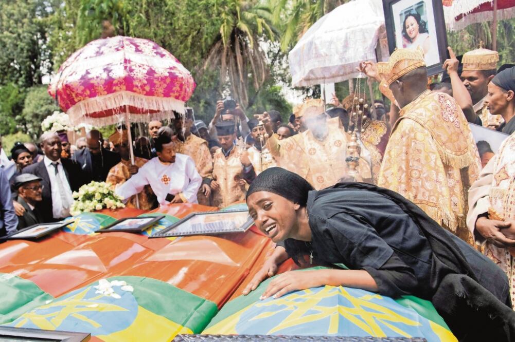 Una mujer se lamenta junto a los ataúdes de las víctimas mortales del accidente aéreo de Ethiopian Airlines, durante una ceremonia de entierro realizada ayer en la Catedral de la Santísima Trinidad. (MAHEDER HAILESELASSIE. REUTERS)