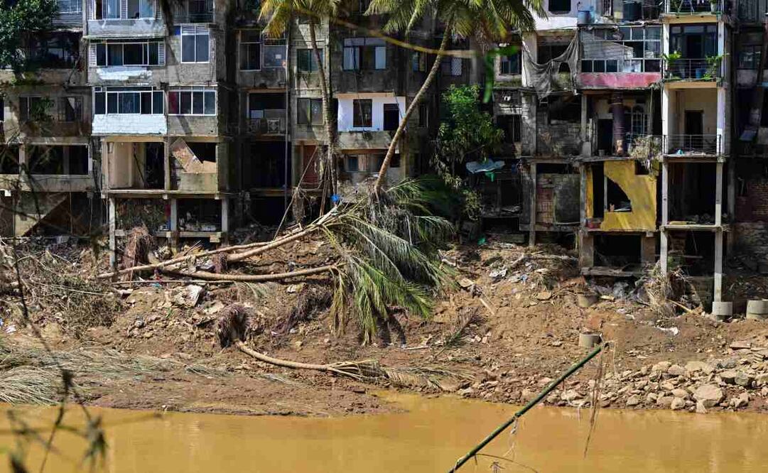 Árboles arrancados yacen cerca de un edificio dañado tras los deslizamientos de tierra tras el paso del ciclón Ditwah en Gampola, Kandy, el 4 de diciembre de 2025. Los pronósticos de lluvia para el 4 de diciembre aumentaron el temor de mayores daños en Indonesia y Sri Lanka, afectadas por las inundaciones, después de que diluvios anteriores causaran la muerte de más de 1500 personas en cuatro países. Foto: AFP