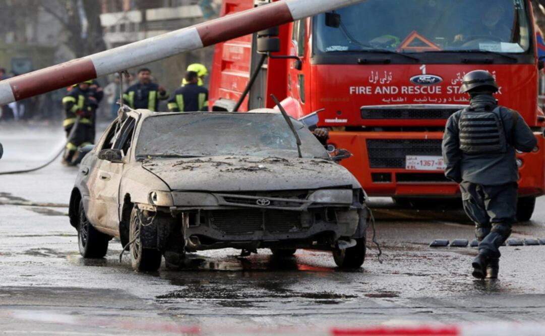 Police officers keep watch while a man drives his heavily damaged car at a car bomb attack site in Kabul Afghanistan – Photo: Omar Sobhani/REUTERS
